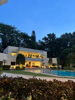 A white house and pool under a blue evening sky.